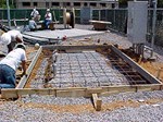 Workers laying reinforcement mesh for tower foundation